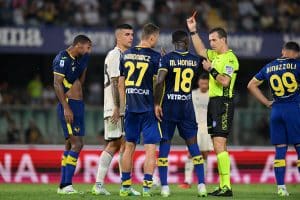VERONA, ITALY - AUGUST 26: Referee, Daniele Doveri shows a red card to Isak Hien of Hellas Verona after a VAR review as Pawel Dawidowicz and Martin Hongla of Hellas Verona protest during the Serie A TIM match between Hellas Verona FC and AS Roma at Stadio Marcantonio Bentegodi on August 26, 2023 in Verona, Italy. (Photo by Alessandro Sabattini/Getty Images)